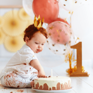 little boy eating cake for first birthday