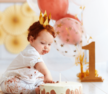 little boy eating cake for first birthday