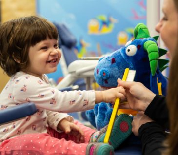 patient in chair with toothbrush at dental appointment