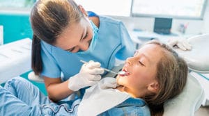 dentist looking in little girl's mouth