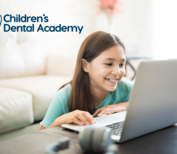 children's dental academy little girl looking at laptop