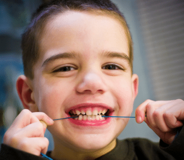 little boy flossing
